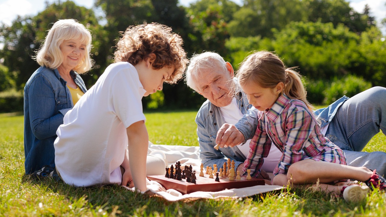 Family playing chess outside on the lawn; image used for HSBC Philippines Important Notice page